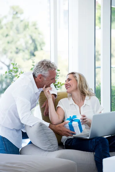 Casal com presente e laptop — Fotografia de Stock