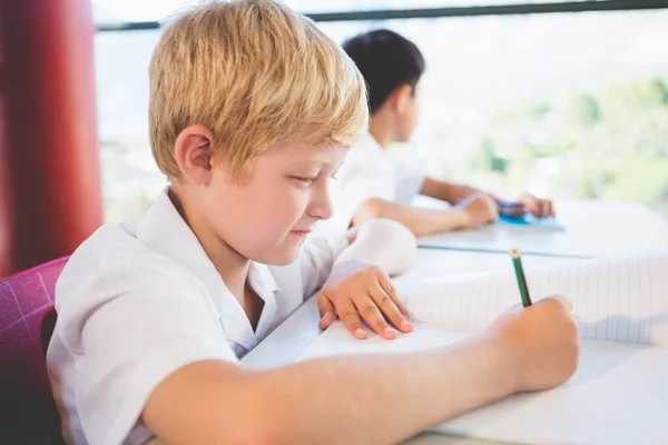 Schoolkid gör läxor i klassrummet — Stockfoto