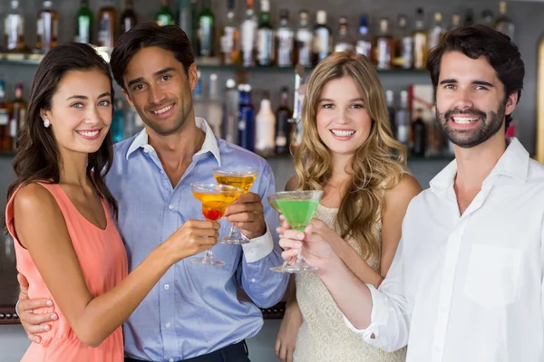 Retrato de parejas felices brindando copas de cóctel — Foto de Stock