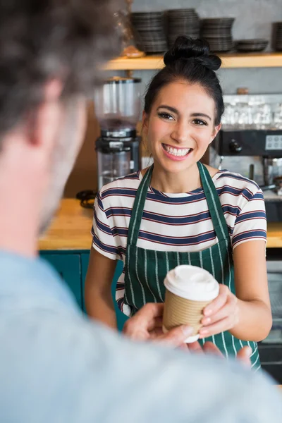 Официантка дает чашку кофе клиенту — стоковое фото