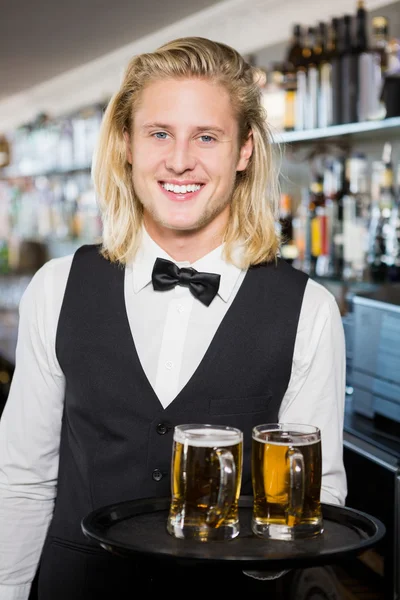 Retrato del camarero sosteniendo bandeja con taza de cerveza — Foto de Stock