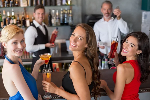 Glückliche Freundinnen mit einem Glas Cocktail an der Theke — Stockfoto