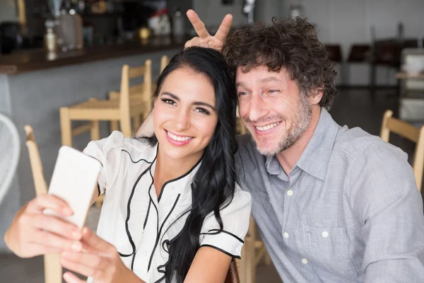 Casal tomando uma selfie na cafetaria — Fotografia de Stock
