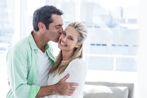 Мужчина целует женщину дома — стоковое фото