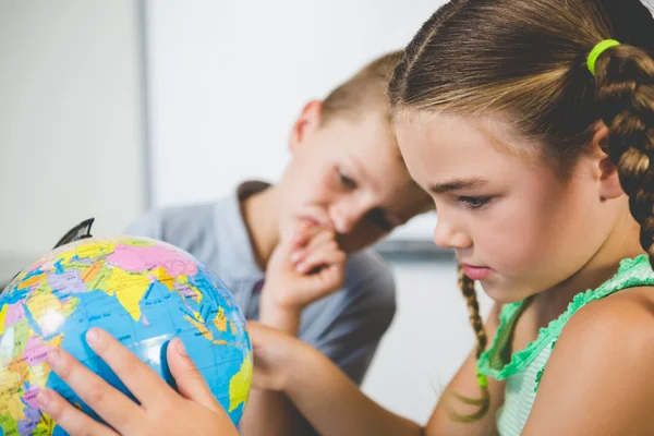 Schüler betrachten Globus im Klassenzimmer — Stockfoto
