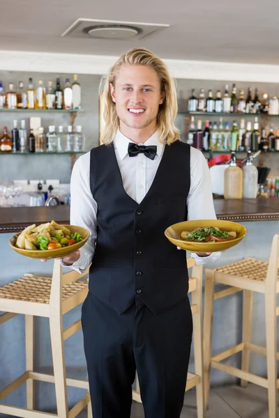 Camarero sosteniendo comidas plateadas en el restaurante — Foto de Stock