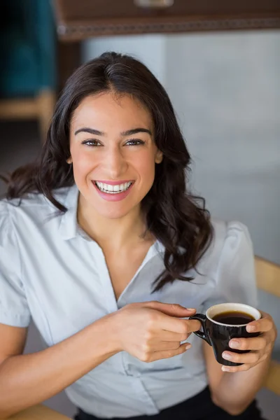 Retrato de una mujer sonriente tomando una taza de café — Foto de Stock