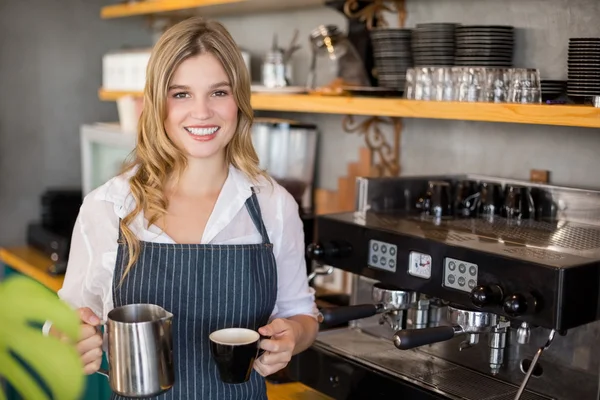 Porträt einer lächelnden Kellnerin, die Kaffee kocht — Stockfoto