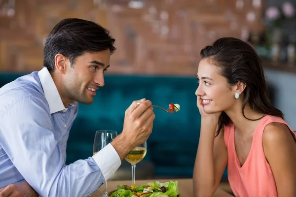 Uomo sorridente che nutre pasto alla donna — Foto Stock