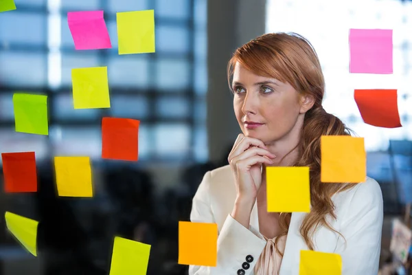 Empresaria mirando notas pegajosas — Foto de Stock