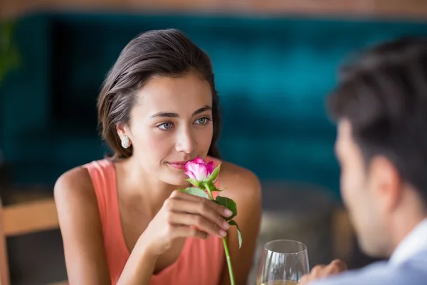 Жінка пахне трояндою, запропонованою чоловіком — стокове фото