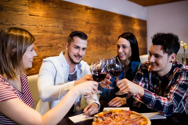 Amigos brindar por el vino en la mesa — Foto de Stock