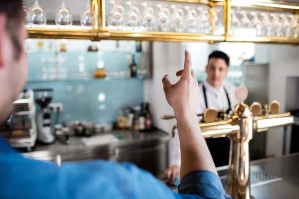 Mann gestikuliert im Gespräch mit Barkeeper — Stockfoto