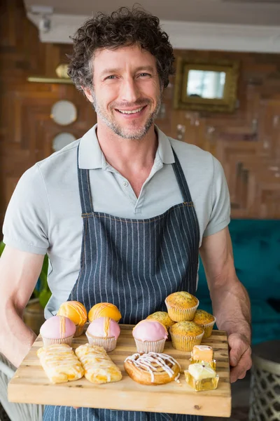 Ober houden van houten dienblad met dessert — Stockfoto