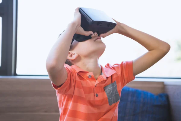 Miúdo da escola usando óculos de realidade virtual na biblioteca — Fotografia de Stock