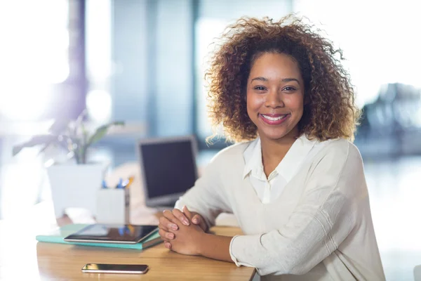 Woman sitting by table in office — Stock Photo, Image