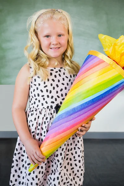 Retrato de colegiala sonriente sosteniendo regalo en el aula — Foto de Stock