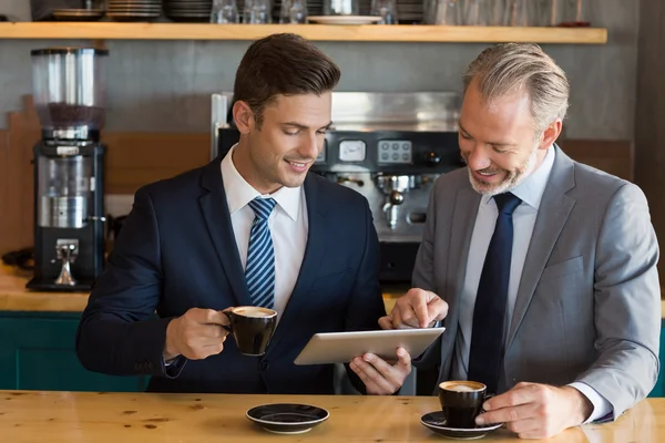 Empresários usando tablet digital no café — Fotografia de Stock