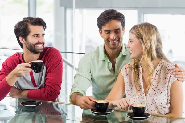 Lachende vrouw en twee mannen met kopje koffie — Stockfoto