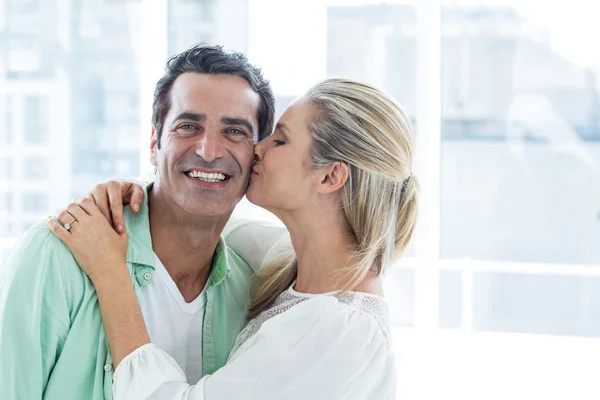 Взрослая женщина целует мужчину дома — стоковое фото