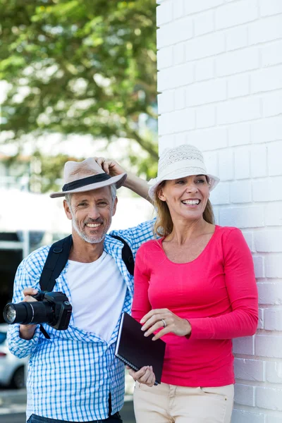 Äldre par stående av vägg — Stockfoto