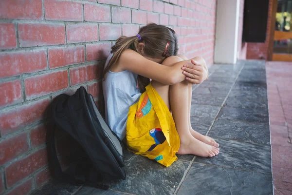 Estudante triste sentado sozinho no corredor — Fotografia de Stock