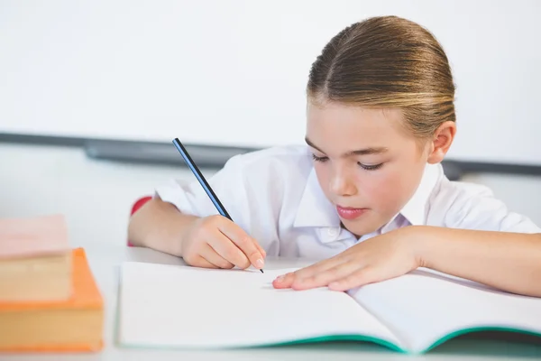 Écolier faisant ses devoirs en classe — Photo