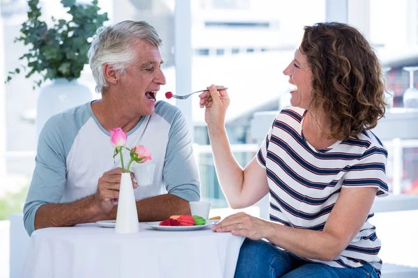 Mujer feliz alimentando al hombre con comida — Foto de Stock