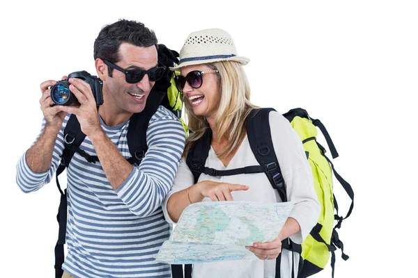 Casal com câmera e mapa transportando bagagem — Fotografia de Stock