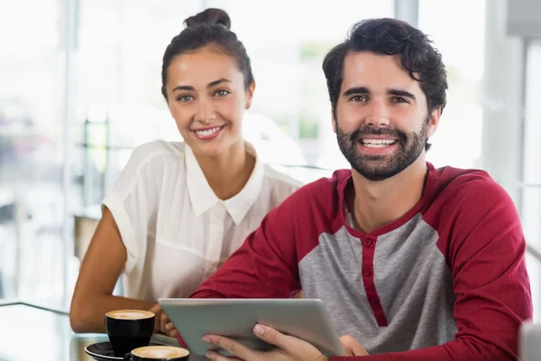 Portret van paar met behulp van digitale tablet in café — Stockfoto