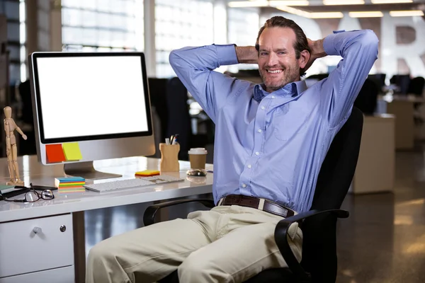 Businessman sitting with hands behind head — Stock Photo, Image