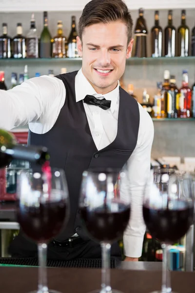 Camarero vertiendo vino en vasos — Foto de Stock