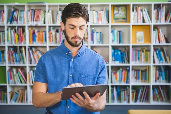 Profesor de escuela usando tableta digital en la biblioteca — Foto de Stock