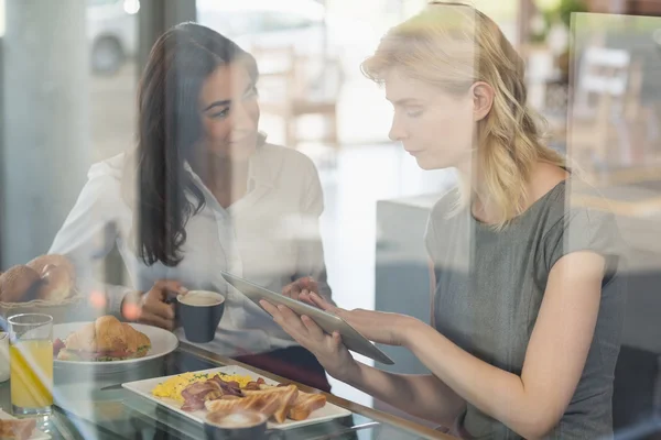 Femmes interagissant les unes avec les autres tout en utilisant une tablette numérique — Photo