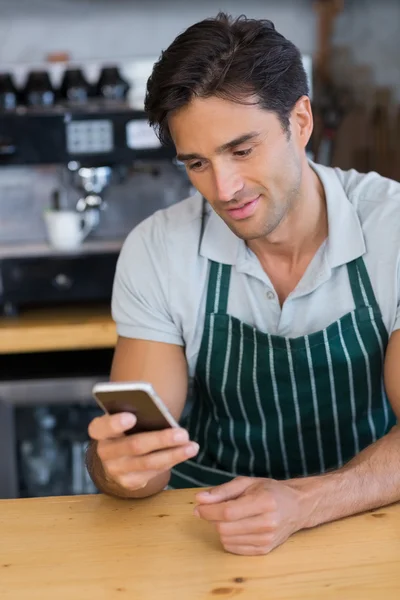Улыбающийся официант с мобильного телефона — стоковое фото