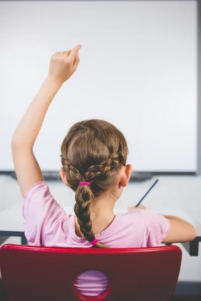Achteraanzicht van schoolmeisje verhoging van haar hand in klaslokaal — Stockfoto