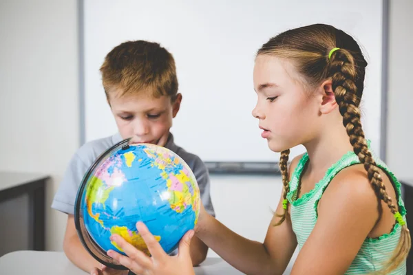 Les écoliers regardent le globe en classe — Photo