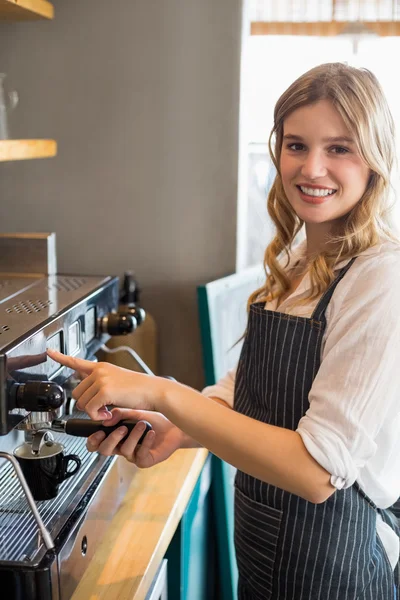 Портрет улыбающейся официантки, делающей чашку кофе — стоковое фото