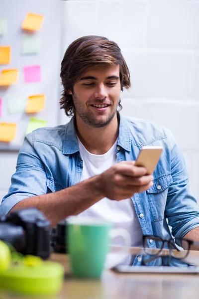 Uomo che utilizza il telefono cellulare in ufficio — Foto Stock