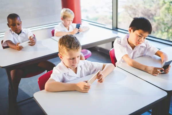 Schoolkids przy użyciu telefonu komórkowego w klasie — Zdjęcie stockowe