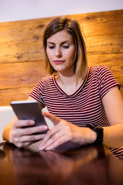 Donna che utilizza il cellulare a tavola — Foto Stock