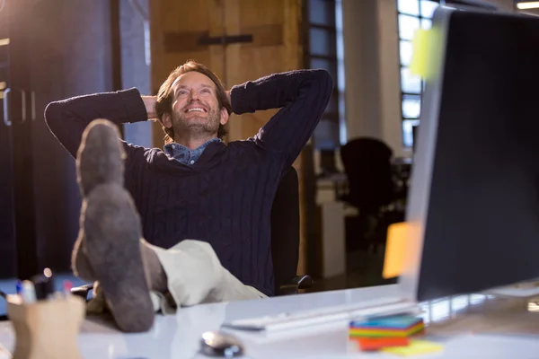 Businessman relaxing by desk — Stock Photo, Image
