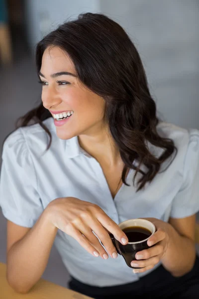 Улыбающаяся женщина пьет кофе — стоковое фото