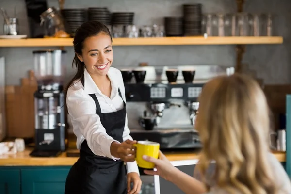 Kellnerin bietet eine Tasse Kaffee an — Stockfoto