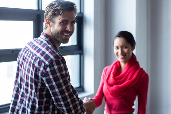 Colleagues shaking hands in office — Stock Photo, Image
