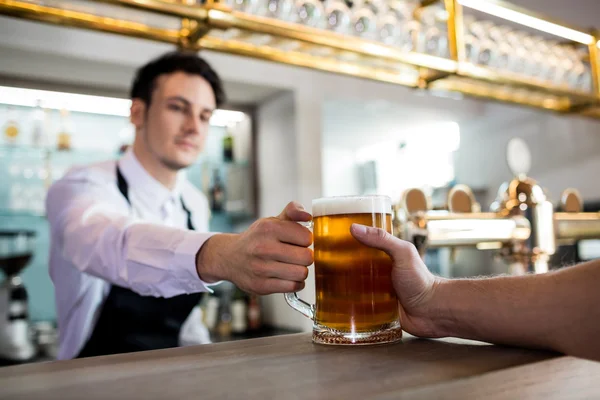 酒吧老板服务啤酒给客户 — 图库照片