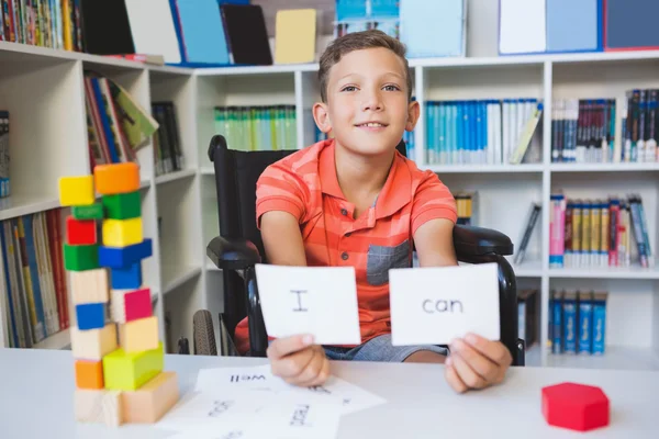 Ragazzo disabile che mostra cartello che recita I Can in biblioteca — Foto Stock