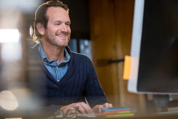 Smiling businessman working on computer — Stock Photo, Image