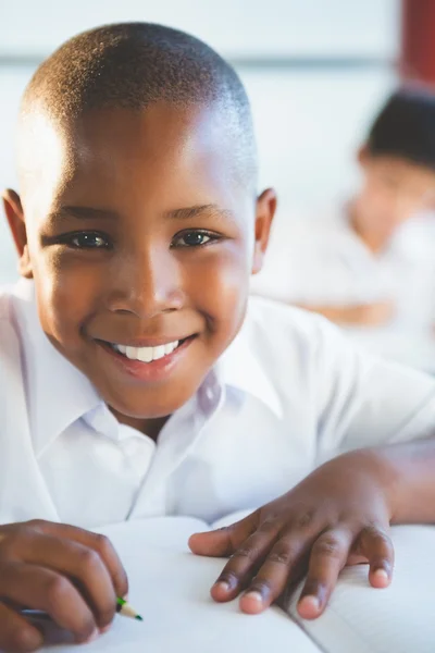 Schoolboy doing homework in classroom — Stock Photo, Image