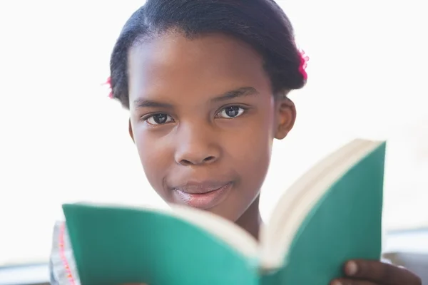 Schoolmeisje leesboek in bibliotheek — Stockfoto